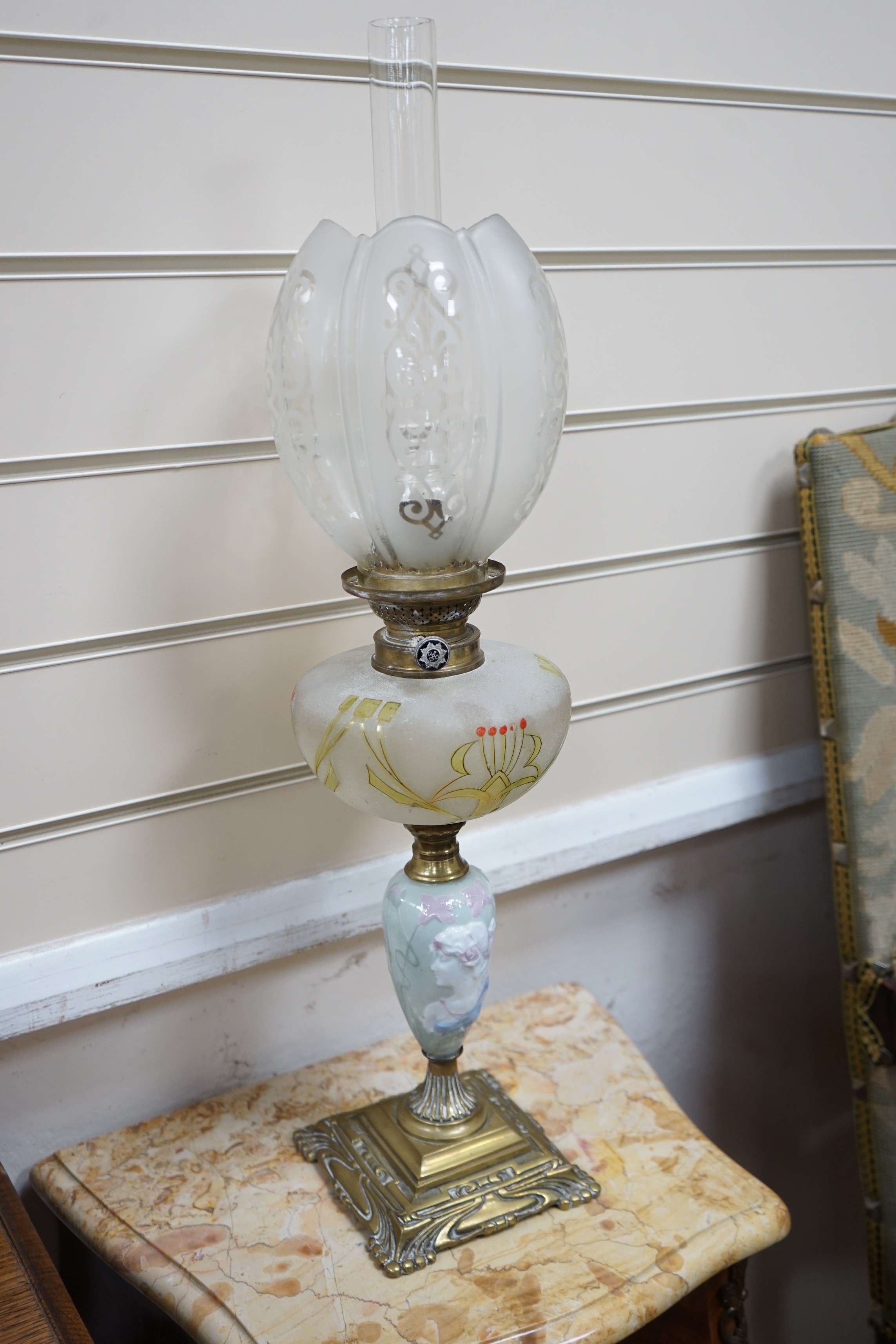 A pair of Art Nouveau decorative porcelain, brass and glass oil lamps. 64cm tall